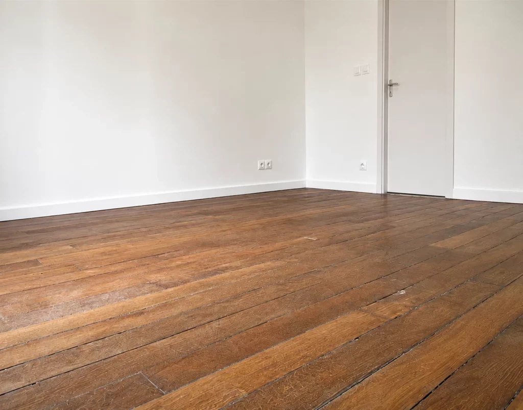 Parquet ancien usé et taché avant restauration